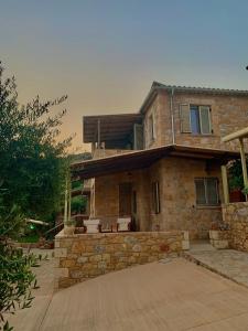 a stone house with a porch and a patio at Riza Apartments in Kardamili