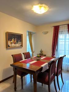 - une salle à manger avec une table et des chaises en bois dans l'établissement Szent György Villa Apartmanház, à Hévíz