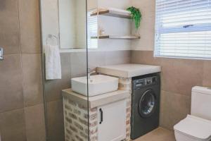 a bathroom with a sink and a washing machine at PontVineyard @ Pont de Val in Parys