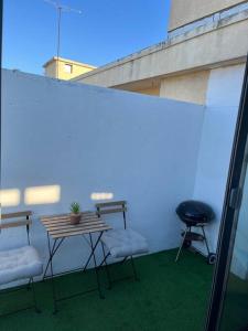 a patio with a table and two chairs and a grill at Charmant type 2 au cœur de la ville in Marseille