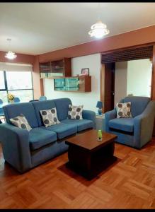 ein Wohnzimmer mit blauen Sofas und einem Couchtisch in der Unterkunft Hermoso departamento en la Ciudad de La Paz-Bolivia in La Paz