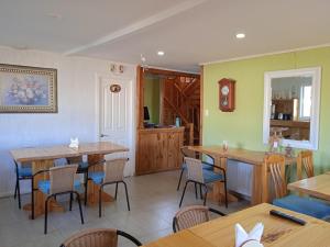 a restaurant with tables and chairs in a room at Hostal JC in Puerto Natales