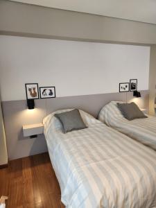 una camera con due letti e due quadri appesi al muro di Loft Urbano Ushuaia a Ushuaia