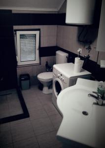 een badkamer met een wastafel en een wasmachine bij Kuća Sunca in Sarajevo