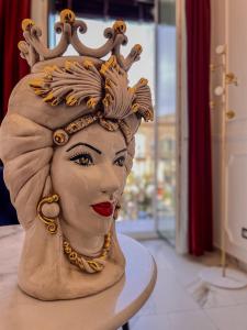 une statue d'une femme avec couronne sur la tête dans l'établissement Ricci Palace Suites, à Catane
