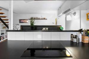 una cocina con encimera en blanco y negro en Lejlighed/rækkehus med adgang til pool., en Vipperød