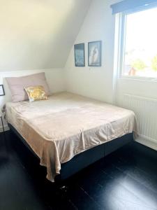 uma pequena cama num quarto com uma janela em Lejlighed/rækkehus med adgang til pool. em Vipperød