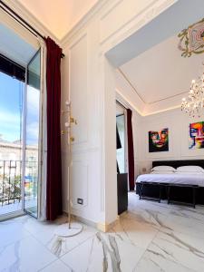 Ricci Palace Suites في كاتانيا: غرفة نوم بسرير ونافذة كبيرة