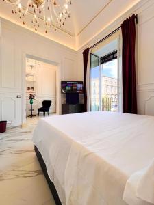 1 dormitorio con 1 cama blanca grande y TV en Ricci Palace Suites en Catania