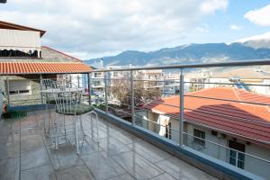 een balkon met uitzicht op sommige gebouwen en bergen bij Lovely Guesthouse - 58m2 mountain view in Ioannina