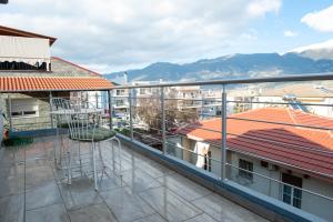 a balcony with a view of some buildings and mountains at Lovely Guesthouse - 58m2 mountain view in Ioannina