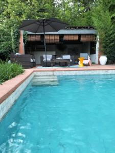 una piscina con sombrilla en un patio en LE 17, en Courthézon