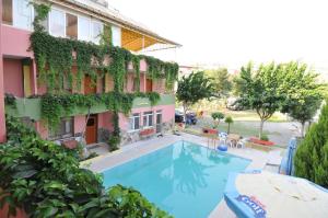 a hotel with a swimming pool in front of a building at Hotel Pamukkale in Pamukkale