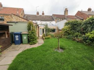 a house with a yard with a small tree in it at Inglenook Cottage in Guisborough