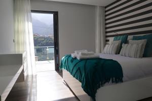 a bedroom with a bed and a large window at Casa Da Achada, By OP in São Vicente +21 photos