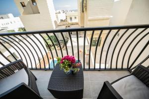 a balcony with a table with a vase of flowers at 49 Sunrise Lodge in Għajnsielem