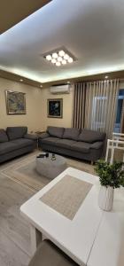ein Wohnzimmer mit Sofas und einem Tisch in der Unterkunft New Bazar Luxury Apartment in Tirana