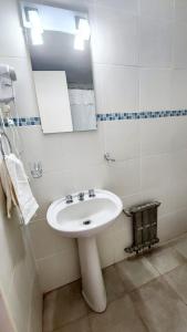 Un baño con un lavabo blanco y un espejo. en Estudio Brendel a metros del Centro Cívico, en San Carlos de Bariloche