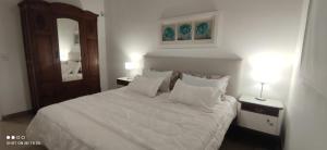 ein Schlafzimmer mit einem Bett mit weißen Laken und Kissen in der Unterkunft Casa de Montaña María Tequila in Villa Giardino