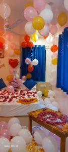 Zimmer mit Ballons, einem Bett und einem Tisch in der Unterkunft Collection O Hotel La Veera in Ahmedabad