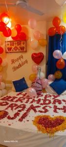 ein Schlafzimmer mit einem Bett mit Ballons und einem Kuchen in der Unterkunft Collection O Hotel La Veera in Ahmedabad