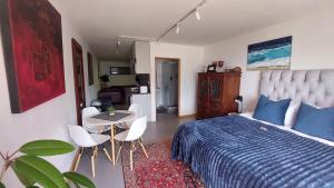 um quarto com uma cama, uma mesa e cadeiras em A Relaxing Getaway with Ocean Views em Cidade do Cabo
