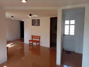 a room with a wooden chair and a door at CASA ACOGEDORA in Chignahuapan