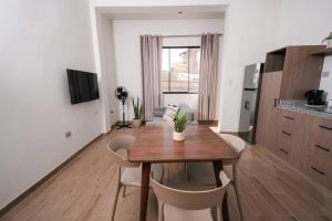 una cucina e una sala da pranzo con tavolo e sedie in legno di CASA MONA 2 - Apartamento en Tarapoto a Tarapoto