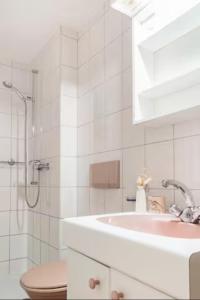 a white bathroom with a sink and a shower at Chambre d'hôte au milieu des vignes avec magnifique vue sur le lac et jardin in Féchy