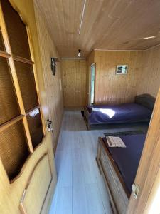 una piccola camera con due letti in una piccola casa di Guesthouse Ivas a Ushguli