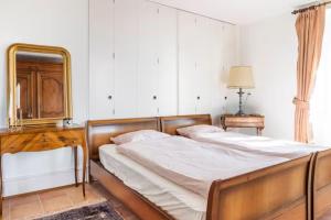 a bedroom with a bed with a mirror and a dresser at Chambre d'hôte au milieu des vignes avec magnifique vue sur le lac et jardin in Féchy