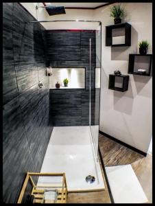 baño con ducha y puerta de cristal en Dante's House - Affittacamere en Módena