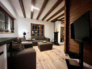 uma sala de estar com um sofá e uma televisão de ecrã plano em Blockhaus Ourtal em Winterspelt