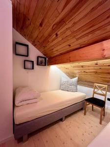 a bed in a room with a wooden ceiling at Blockhaus Ourtal in Winterspelt