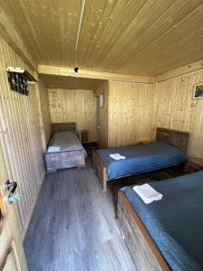 a room with two beds in a wooden cabin at Guesthouse Ivas in Ushguli