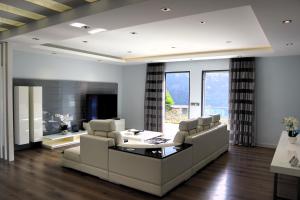 a living room with white furniture and a large window at Casa Da Achada, By OP in São Vicente