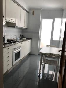 a kitchen with white cabinets and a table and a window at Increíbles vistas *CENTRO* in Pontevedra