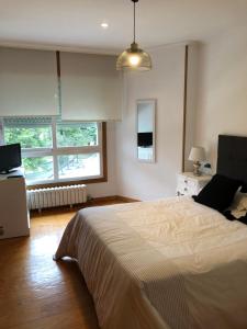 1 dormitorio con 1 cama con ordenador portátil en Increíbles vistas *CENTRO*, en Pontevedra