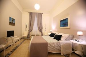 una camera con un letto e una televisione di GUESTHOUSE GRANDI STAZIONI _ bari centro s.l._ a Bari