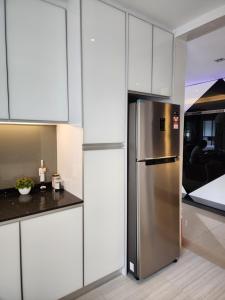 a stainless steel refrigerator in a kitchen with white cabinets at Peony Square Residences in Cameron Highlands