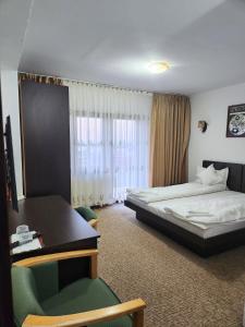 a hotel room with a bed and a desk at Pensiunea Emma in Sâmbăta de Sus