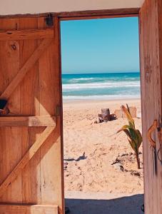 an open door to a beach with the ocean at Beach and sunset villa in Mboro