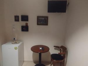 une salle à manger avec une table, des chaises et une télévision dans l'établissement Στούντιο Στη Στοά Βαρβουτσή Νούμερο#7, à Kalamata