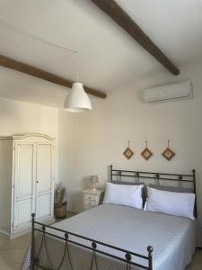 una camera da letto con un letto con lenzuola bianche e una lampada di Agriturismo Masseria Chicco Rizzo a Sternatia