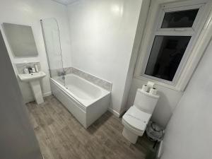 a white bathroom with a toilet and a sink at Luxe Hotel Blackpool in Blackpool
