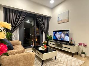 a living room with a couch and a flat screen tv at Premier Suites at STAR in Kuala Lumpur