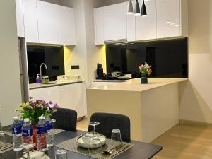 a kitchen with white cabinets and a table and chairs at Premier Suites at STAR in Kuala Lumpur