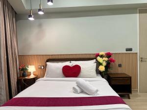 a bedroom with a bed with a red heart pillow at Premier Suites at STAR in Kuala Lumpur