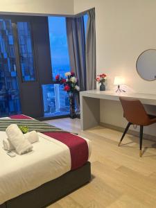 een slaapkamer met een bed, een bureau en een raam bij Premier Suites at STAR in Kuala Lumpur