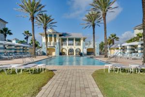 una piscina frente a una casa con palmeras en Spacious Palm Coast Condo Balcony, Beach Access!, en Palm Coast